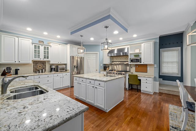 Kitchen with white cabinets granite counters and hard wood flooring